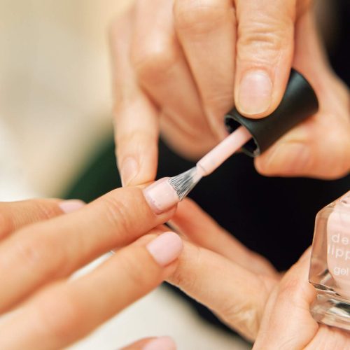 Aplicación de esmalte en manicura en centro estético en Barrio Salamanca